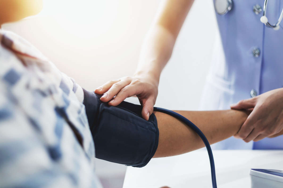 A young nurse is measuring the pressure of a patient who is admi